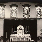 5.	Priesterkoor in de noodkerk van O.L.V. van Lourdes (KoningshoevenOp de achtergrond de glas-in-lood ramen met van links naar rechts de H. Albertus, O.L.V. van Lourdes, St. Jozef en St. Dionysius. 	