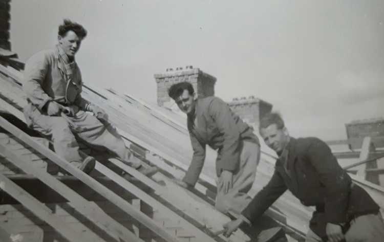 Timmermannen op het schuine dak van de flats aan de Ringbaan West / Nassaustraat